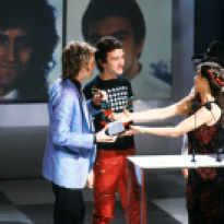 roger-taylor-and-john-deacon-receiving-the-award-for-favourite-pop-single-for-another-one-bites-the-dust-from-barbi-benton-and-johnny-paycheck-american-music-awards-january-1981